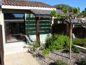 a green house with a porch and a tree at Residence Les Sellettes in Saint-Tropez