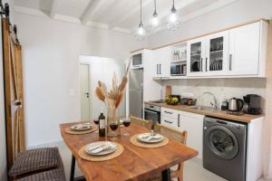 a kitchen with a wooden table with chairs and a sink at Alex Studios & Apartments in Arillas