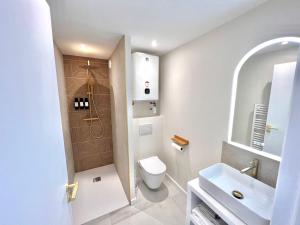 a white bathroom with a toilet and a sink at Saint Cyprien, superbe appartement calme proche du port, parking in Saint-Cyprien