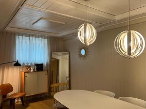 ein Esszimmer mit einem weißen Tisch und zwei Leuchten in der Unterkunft Seoul Kyeongbokgung Stay in Seoul