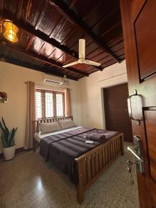 1 dormitorio con 1 cama grande en una habitación en Glanwoods Inn - 2BHK Antique house - Pets allowed, en Mangalore