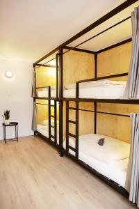 three bunk beds in a room with a table at Schöndorf Hostel - virtual reception in Bratislava