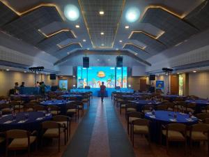 a large banquet hall with blue tables and chairs at Vythiri Village in Vythiri