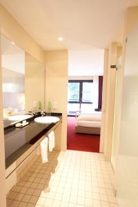 格羅瑙的住宿－施普斯酒店，一间带水槽的浴室和一张位于客房内的床