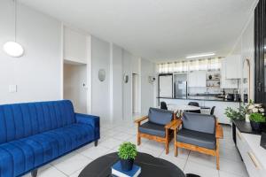 sala de estar con sofá azul y sillas en Seagull 311 en Margate