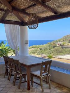 una mesa y sillas en un patio con vistas al océano en Ville Pollara, en Pollara