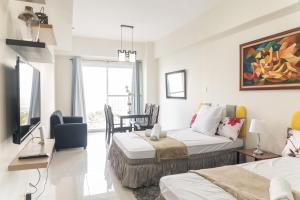 - un salon avec deux lits et un canapé dans l'établissement Wind Residence 4, à Tagaytay