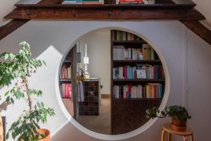 a round mirror in a room with bookshelves at Cozy 55 m close to the Seine in Saint-Denis