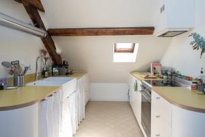 a kitchen with white cabinets and a sink at Cozy 55 m close to the Seine in Saint-Denis