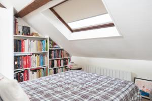 a bedroom with a bed and a book shelf with books at Cozy 55 m close to the Seine in Saint-Denis