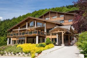 a large wooden house with a balcony at Hotel Alpen Roc in La Clusaz