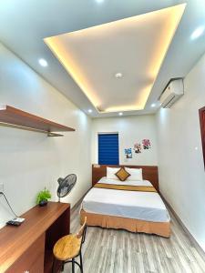 岑山的住宿－Khách sạn Xanh Tốt FLC Sầm Sơn，一间卧室配有一张床、一张桌子和一张四柱床。