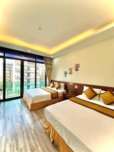 Habitación de hotel con 2 camas y ventana grande. en Khách sạn Xanh Tốt FLC Sầm Sơn en Sầm Sơn