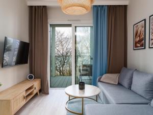 a living room with a couch and a table at Miami Beach z Widokiem na Morze by Perłowa Przystań Rent in Sianozety