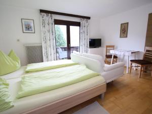 um quarto com uma cama, um sofá e uma cadeira em Cozy Apartment in Niedernsill near lake em Niedernsill