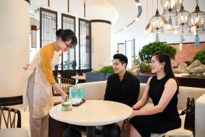 Emerald Ho Tram Resort في هو ترام: ثلاثة أشخاص يجلسون حول طاولة في مطعم