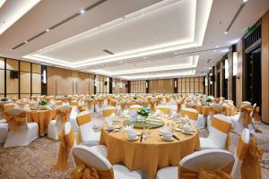 a large banquet hall with tables and white chairs at Emerald Ho Tram Resort in Ho Tram +123 photos
