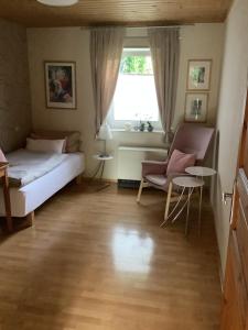 a bedroom with a bed and a window and a chair at Landleben - Ferienhaus 1 in Fritzlar