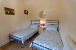 1 Schlafzimmer mit 2 Betten und einem Spiegel in der Unterkunft Five Cottages in AONB in Ashford
