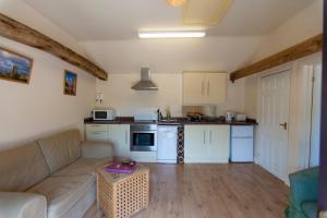 a living room with a couch and a kitchen at Five Cottages in AONB in Ashford