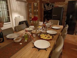 uma mesa de madeira com pratos e tigelas de comida em Bellevue em Lamagistère