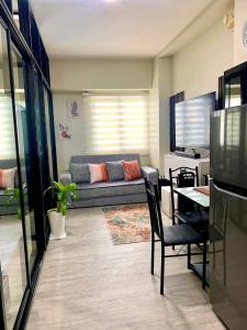 Χώρος καθιστικού στο 2 BEDROOM CONDO close to SM Tungko BULACAN ideal for Family Queen bed on Bedroom 1 accessible to Bedroom 2 with sliding doors Free Wifi & Netflix to watch in a comfy sofa & twin bed Access to SWIMMING POOL entry is very affordable and kids get for free