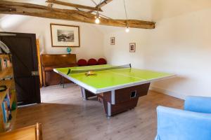 een tafeltennistafel in een kamer met een tafeltennisbal bij Five Cottages in AONB in Ashford