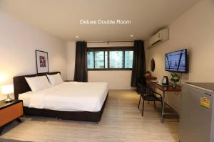 a hotel room with a bed and a desk at Studio F Sukhumvit in Bangkok