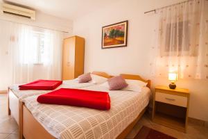 een slaapkamer met een bed met twee rode kussens erop bij Old Town Accommodation in Bol