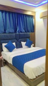 a bedroom with a large bed with blue pillows at Hotel Nest pride in Ahmedabad