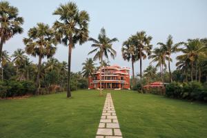 una casa en un césped con palmeras en Tatasth Beach Villa, en Kundapur