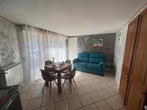 uma sala de estar com uma mesa e um sofá azul em Villa Chapulay em Valencin