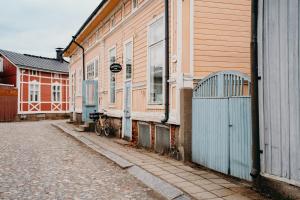 una fila de casas en una calle al lado de un edificio en Idyllinen huvikumpu Vanhan Rauman ytimessä, In the heart of Old Rauma en Rauma
