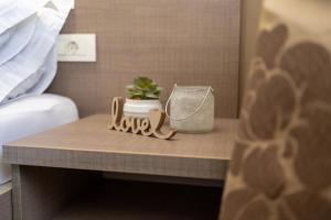 a nightstand with a cactus and a plant on it at Hotel Narenta in Metković