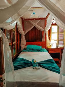 a bedroom with a canopy bed with blue sheets at Dune Alaya Ecolodge in Pemuteran