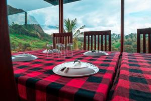 a table with a plaid table cloth and plates on it at Exotica Holidays in Viripara