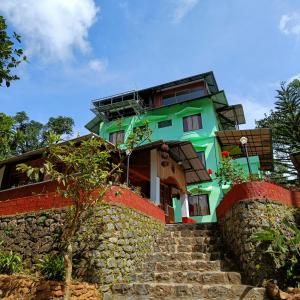 a green building with stairs leading up to it at Exotica Holidays in Viripara