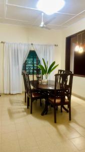 a dining room with a table and chairs and a plant at Va’s home in Kilifi