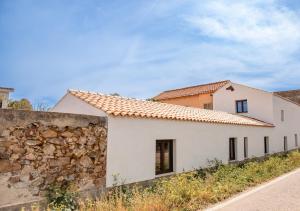 een wit huis met een stenen muur bij Casa Feraxi at Casa Sardinia in Muravera