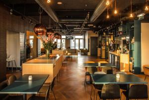 ein Restaurant mit Tischen und Stühlen und eine Bar in der Unterkunft Amadi Panorama Hotel in Amsterdam