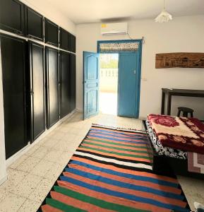 Zimmer mit blauer Tür und farbenfrohem Teppich in der Unterkunft Anis 2 in Sousse