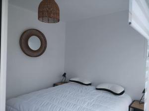 a bedroom with a bed and a mirror on the wall at Appartement St Cast, à 100m de la Grande Plage in Saint-Cast-le-Guildo