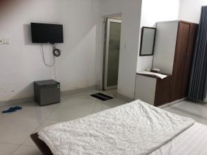 een slaapkamer met een bed en een flatscreen-tv bij Kiều Thủy Hotel in Bao Loc