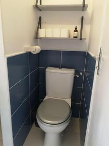 a small bathroom with a toilet and blue tiles at Appartement St Cast, à 100m de la Grande Plage in Saint-Cast-le-Guildo