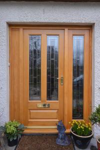 a wooden door with two windows and some plants at Home Farm Bed and Breakfast in Muir of Ord