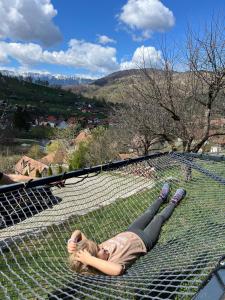 a young girl laying on a climbing net at On Top Chalet in Bran