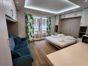 a bedroom with a bed and a couch and a window at Bluemarine, studio vista Mare in Menton
