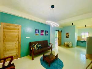 - un salon avec un canapé et un mur bleu dans l'établissement Jhong Apartment, à Boracay