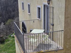 a balcony of a house with a table and a chair at casa nel verde Cà dla cola in Mombasiglio