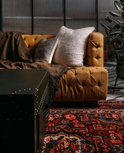 um sofá castanho com almofadas na sala de estar em The LUTF em Nova Deli